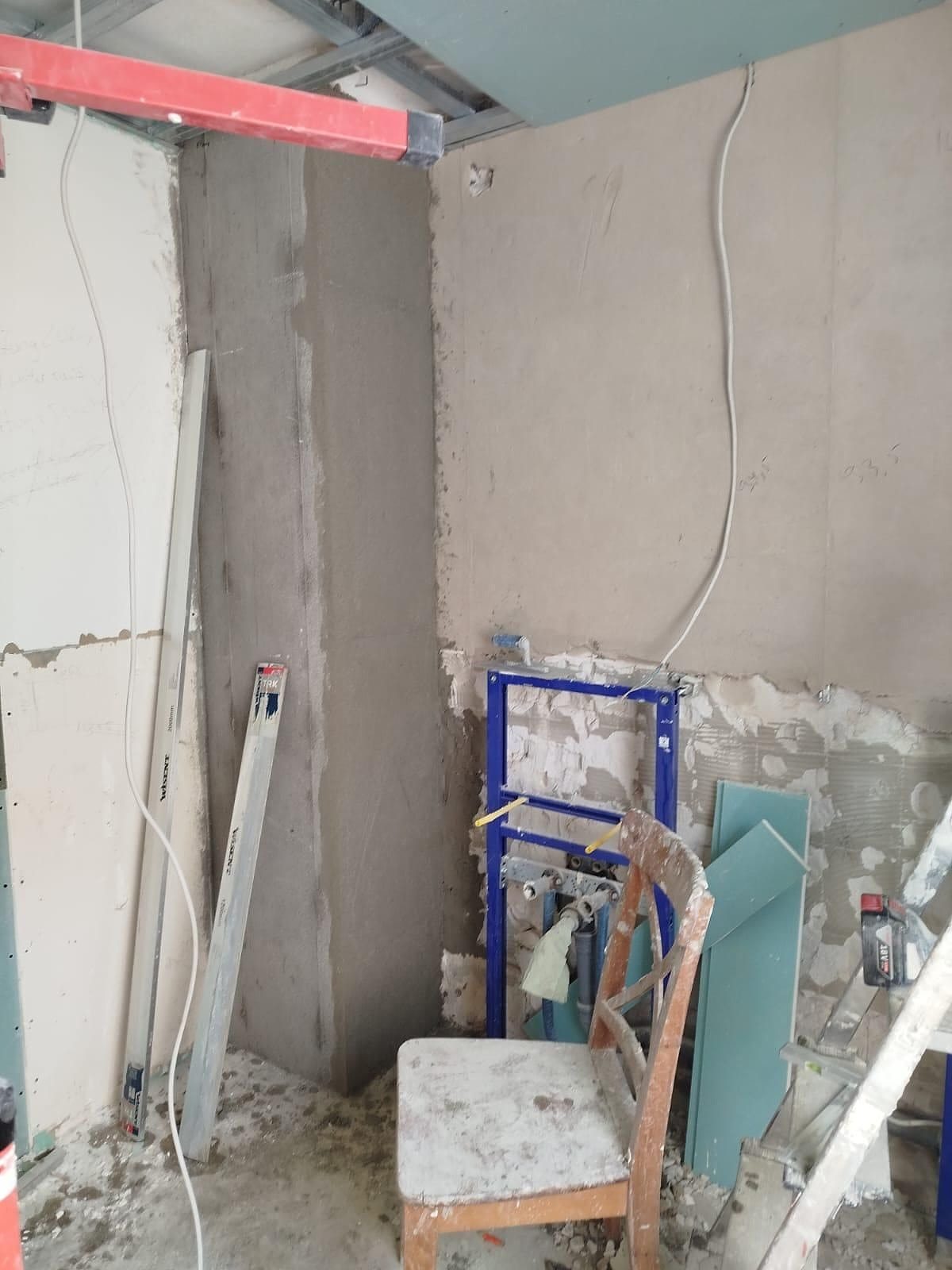 Rohbau: Installationselement für das Wand-WC, daneben eine frisch verputzte Wandfläche