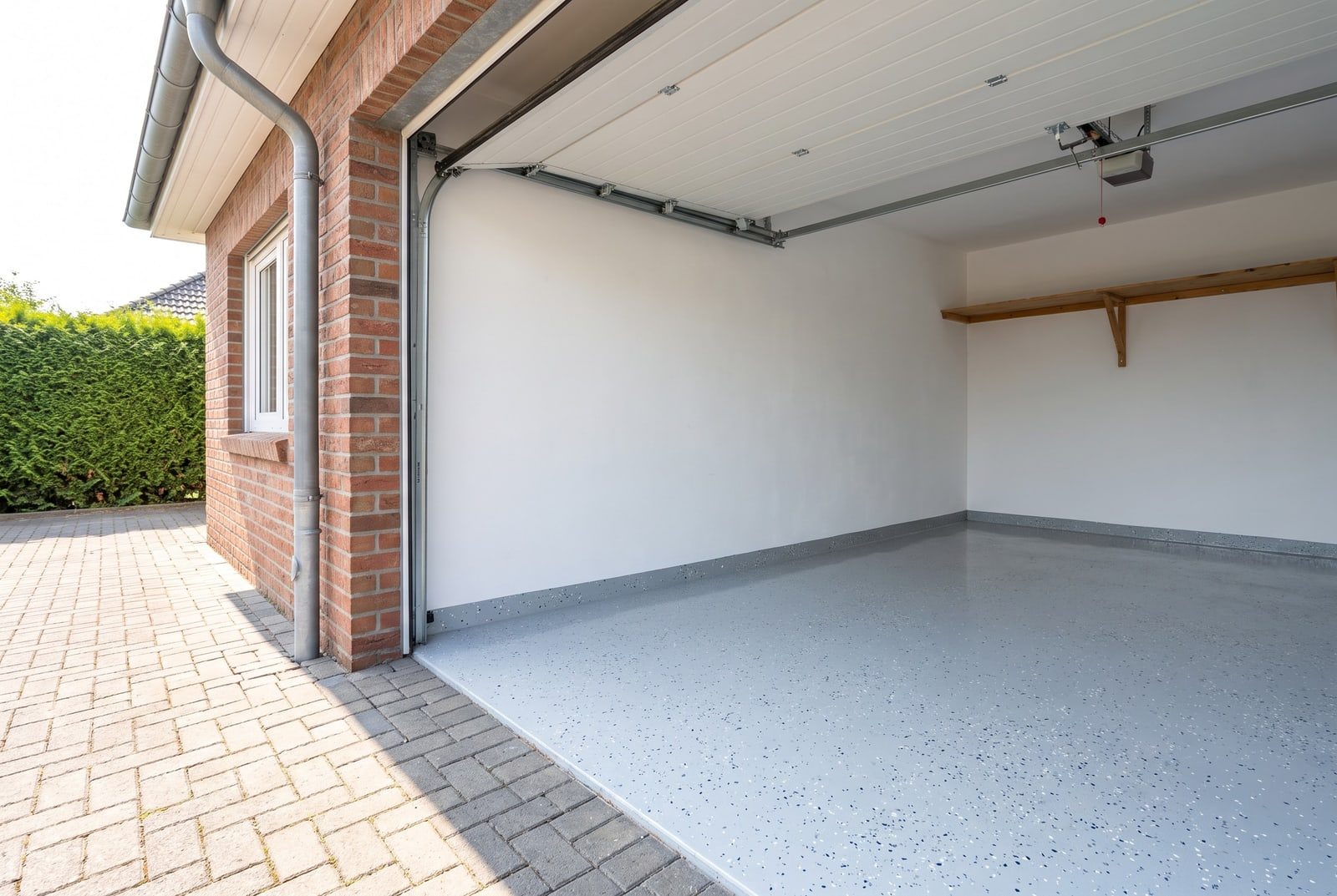 Offene Garage mit hellgrauer Bodenbeschichtung mit Farbchips und frisch gestrichenen Wänden