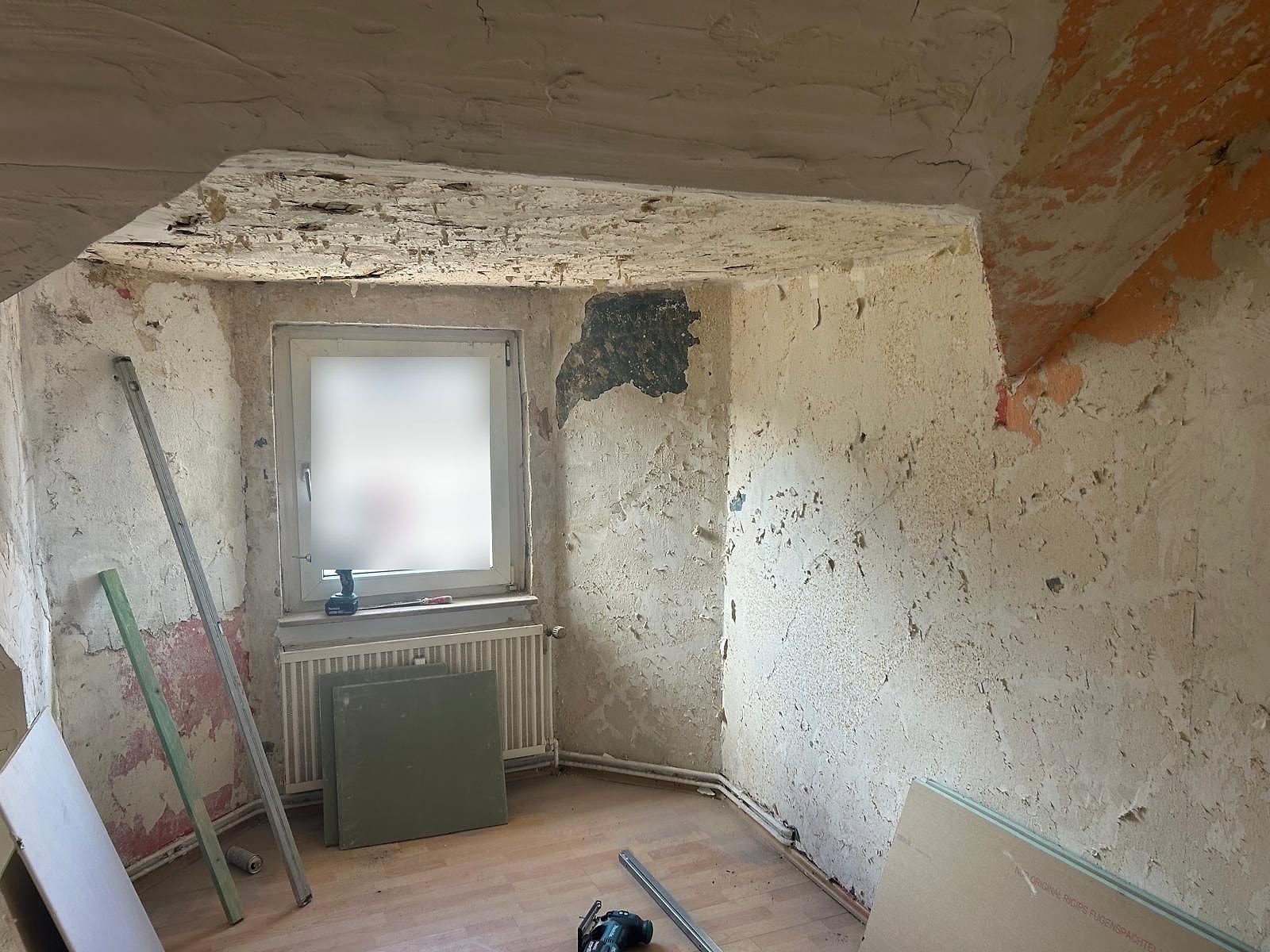 Dachzimmer vor der Sanierung: abgelöste Farbschichten, beschädigte Decke