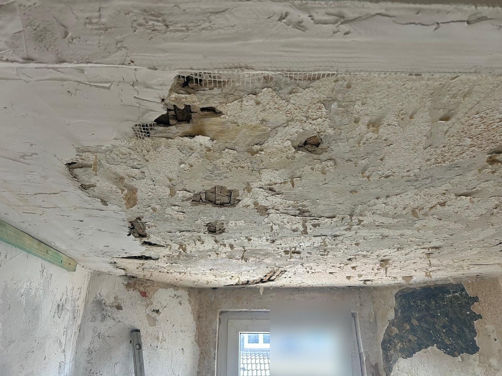 Decke mit Rissen und abgeplatzten Schichten