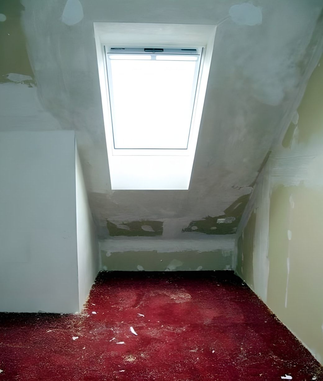 Dachgeschosszimmer vorher: abgerissene Tapete, alter roter Teppich