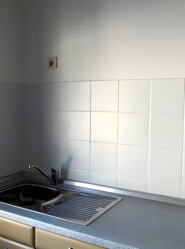 Küche nachher: saubere Fliesenwand mit Spüle