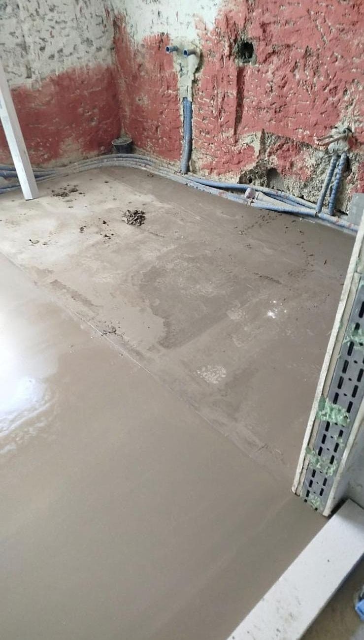 Rohbau: frischer Bodenausgleich, Leitungen an der Wand verlegt