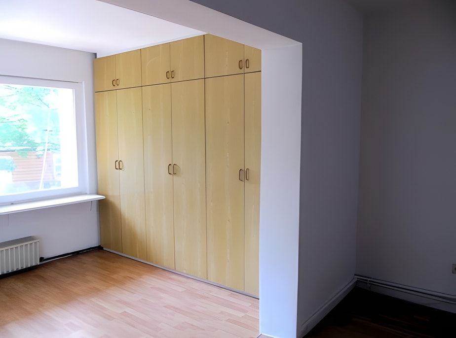 Wohnraum nachher: weiß gestrichene Wände, Einbauschrank, neuer Boden
