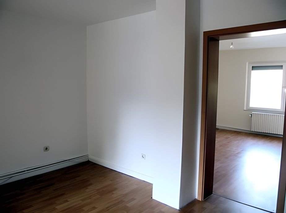Zimmer nachher: glatte weiße Wände und Laminatboden