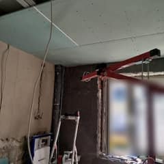 Unterkonstruktion aus Metallprofilen, die Deckenplatten werden mit dem Plattenheber montiert