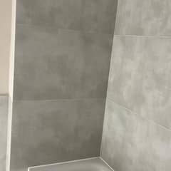 Großformatfliesen an der Wand über der Badewanne