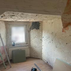 Dachzimmer vor der Sanierung: abgelöste Farbschichten, beschädigte Decke